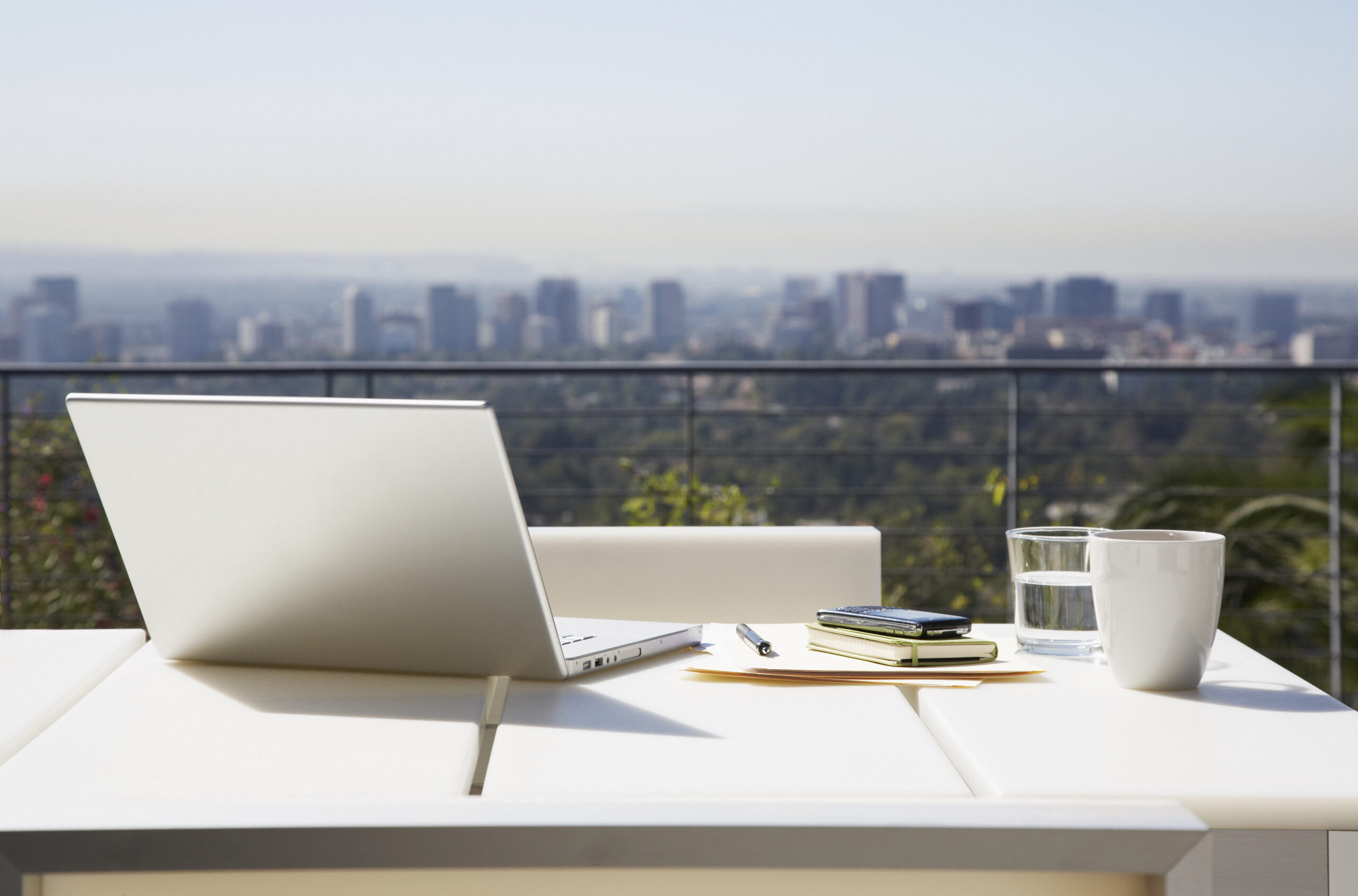 Laptop and paperwork on balcony table